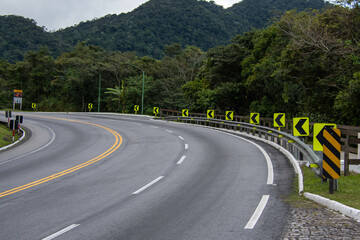 On the way up the mountain, the signaled curve warns drivers with reflective signs and vivid paint....