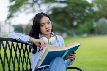 Asian female college student thinking outside with bag and book in a park, Education studying...