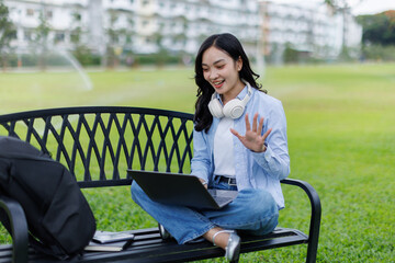 Asian female college student thinking outside with bag and book in a park, Education studying...
