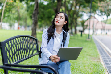 Education, studying, students, Happy young asian girl sitting on green lawn and doing her work on laptop, Education studying students concept
