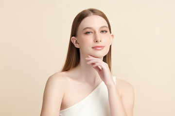 A beautiful young woman with clean, fresh skin against a beige background. Skincare, facial...
