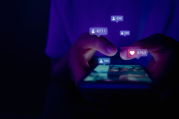 Hands holding a smartphone showing many social media notifications