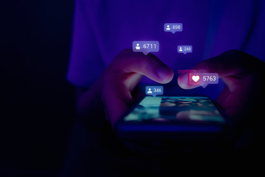 Hands holding a smartphone showing many social media notifications