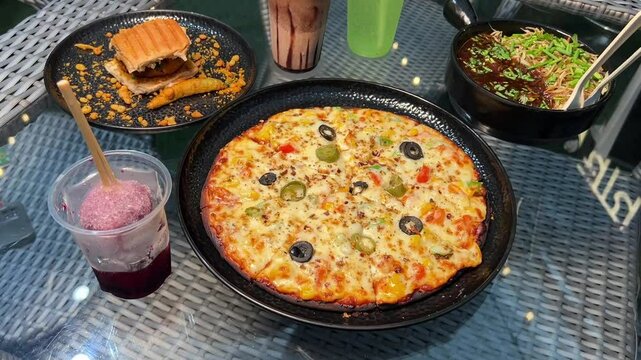 Vada pav, Veg pizza, chowmein and veg manchurian, Kala khata ice gola served in a local restaurant in Kolkata, India 