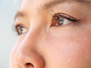 Macrophotography shot of Asian woman's eyes with close-up on eyelashes and pupil.