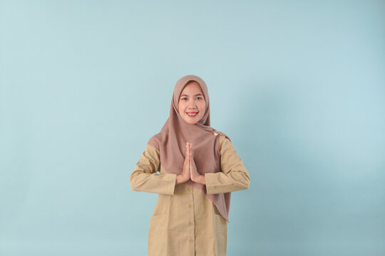 Smiling government worker with khaki uniform she is posing namaste greeting hands picture PNS, ASN civil servant concept.