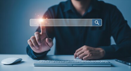A person touches a search bar on a screen with a keyboard and mouse