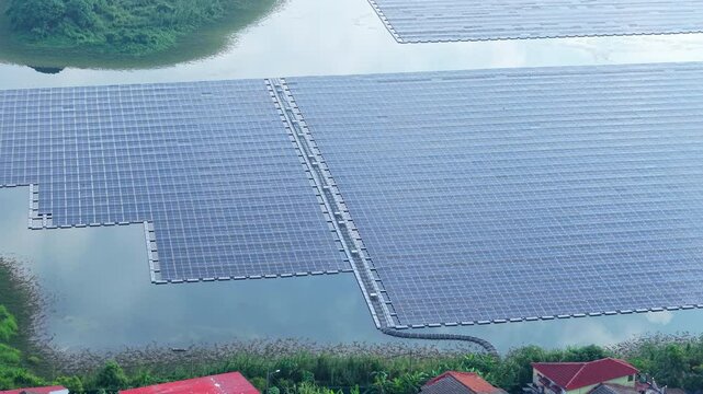 Close up Solar Panels, Aerial view of a floating solar panel farm concept on a serene tropical lake in Rawang, Malaysia. Clean renewable energy landscape in Southeast Asia.
