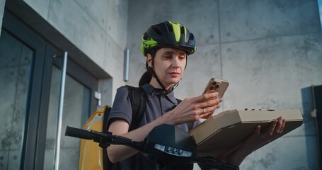Delivery Woman Wearing Bicycle Helmet Standing near Office Building, Notifying Client about...