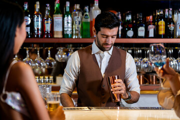 A charismatic bartender or mixologist smiles at a customer while preparing a craft cocktail with a shaker A concept for the hospitality industry and expert service