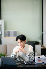 Overworked young Asian businessman office worker suffering from neck pain after had a long day at...