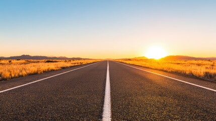 Long Straight Road through Desert Landscape at Sunrise.