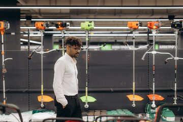 Man Exploring Gardening Equipment in a Store for Professional and Personal Use