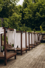 Wooden gazebos with curtains providing relaxation by the poolside