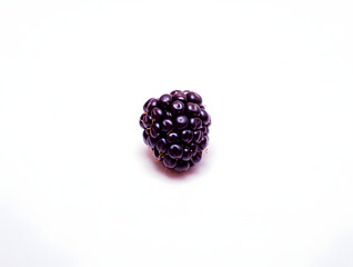 A single ripe and juicy blackberry, resting on a crisp white background, showcasing its deep purple hue and intricate texture in a minimalist composition.