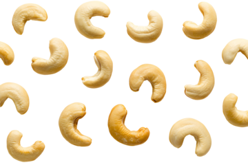 Scattered raw cashews on stark black background, showcasing natural textures