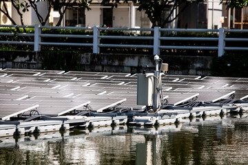Selective focus to solar power station. Solar photovoltaic power station on water. Solar panels or solar cells on buoy floating in lake.  Power plant with water.