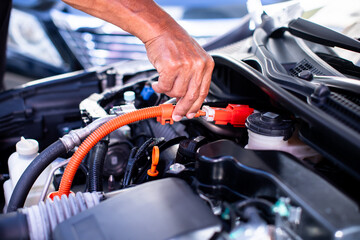 Mechanic's hands are checking engine equipment EV engine car. EV engine car engine block under hood...