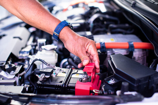 Mechanic's hands are checking engine equipment EV engine car. EV engine car engine block under hood electric vehicle high power and environmentally .