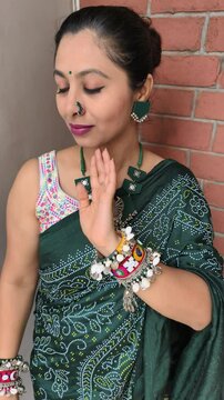 Indian woman dressed in traditional green bandhani saree with oxidized fabric jewelry and colorful kodi bangles, showcasing her outfit. Embracing Hindu festive look for Hariyali Teej in shravan month.