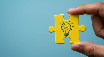 Hand holding yellow puzzle piece with lightbulb idea symbol on blue background