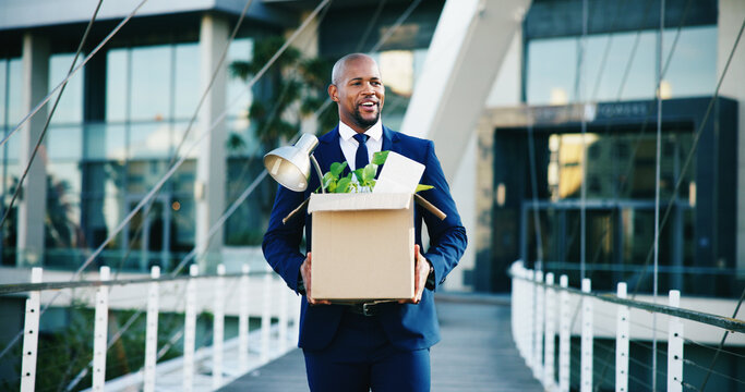 Black man, leaving and business with box for new career, job opportunity or migration in city. Happy, businessman and smile with work equipment or belongings for employment promotion or relocation