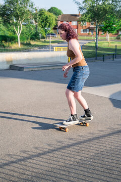 Young girl riding on her skateboard, outdoor kids activities