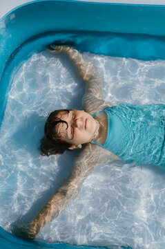 Child girl swimming in glasses in a pool on the back.