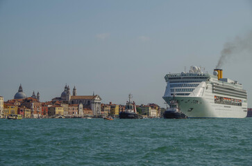 Italian luxury cruise ship Victoria cruising the Giudecca Canal with tug boats towards the cruise...