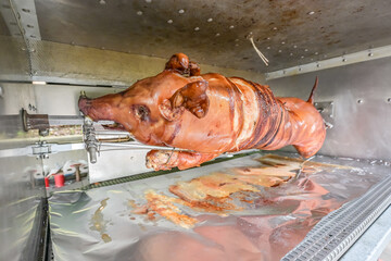 Barbecue with young pig grill Whole roasted piglet body turning on grill. Large barbecue in the...