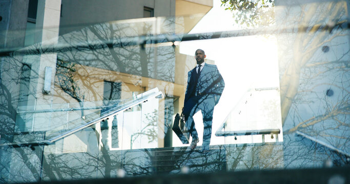 Low angle, business and man in city, walking and travel with urban town, glass and pride. Outdoor, person and employee with steps, stairs and commute with buildings, reflections and New York