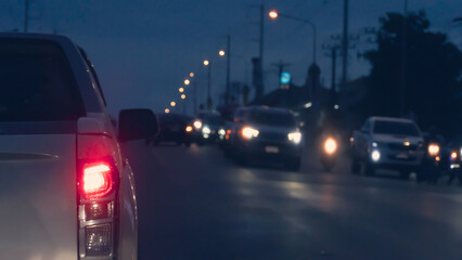 Abstract rear side of car with open trail light. Stop on asphalt road. with other car turn on the light coming from the opposite lens.