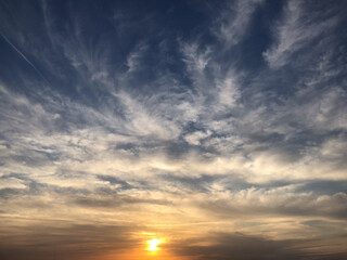 Dramatic Sunset Sky with Soft Clouds and Golden Light at Horizon