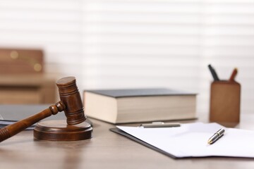 Judge. Gavel, book, papers and pen on wooden table in office, selective focus