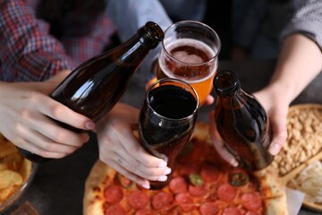 Friends with beer and snacks at grey table, closeup