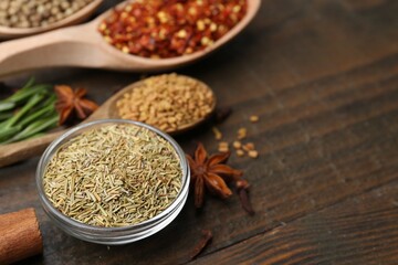 Different aromatic spices on wooden table, closeup. Space for text