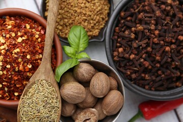 Different aromatic spices on white wooden table, closeup