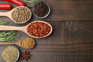 Different aromatic spices on wooden table, flat lay. Space for text