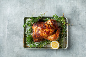 A top down view of a rotisserie chicken, on a baking sheet.