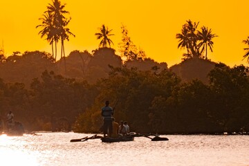 Scenic view of Tourists on a wooden dugout canoe in the meandering estuary of the Kongo River in Diani Beach at sunset in Diani Beach, Kenya 