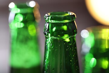 Bottle of tasty beer on blurred grey background, macro view