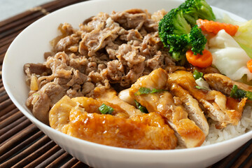 A closeup view of a bowl of beef gyudon and chicken teriyaki.