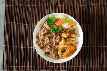 A top down view of a bowl of beef gyudon and chicken teriyaki.