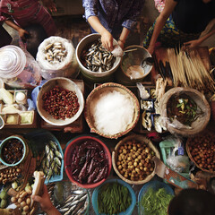 Street food vendors preparing traditional dishes at a vibrant asian market
