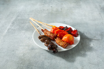 A view of some Filipino style BBQ skewers, on a plate.