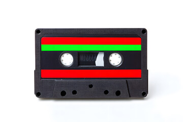 Obraz premium A black vintage cassette tape with red and green stripes stands out on a clean white background. This nostalgic object evokes memories of analog music and retro aesthetics. Ideal for music-themed proj