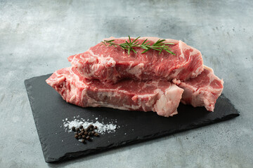 A view of a stack of choice New York steaks, on a slate board.