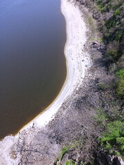 View from the Arch Bridge on the calm water surface of the Dnieper that washes the sandy shores and rocky cliffs of Khortytsia Island.
