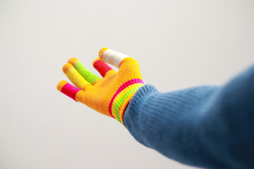 A brightly colored glove with individual finger sheaths outstretched in gesture