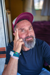 Laid back traveler lounging at campervan entrance, leaning head on hand during peaceful roadside moment